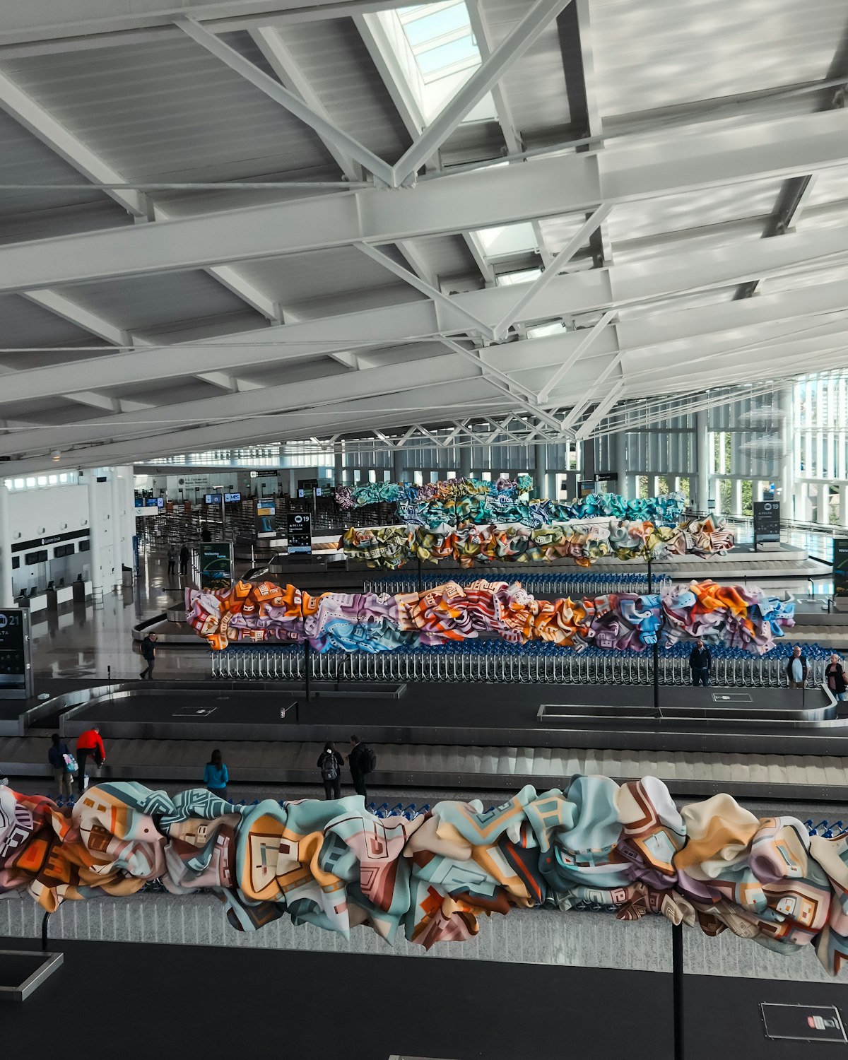 Airport baggage claim hall with parallel carousels and luggage carts