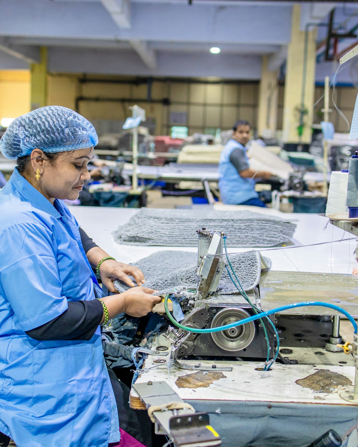A garment factory floor with industrial sewing stations and textile work in progress
